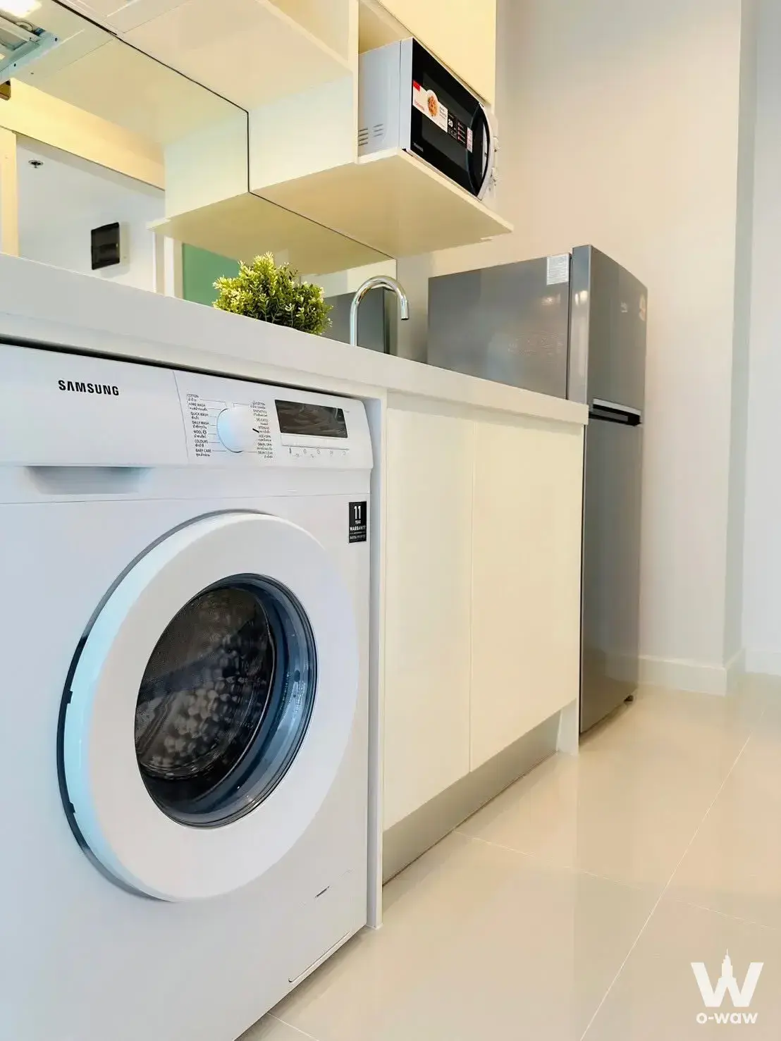 Compact kitchenette with white cabinets and stainless sink in The Sky Sukhumvit condo