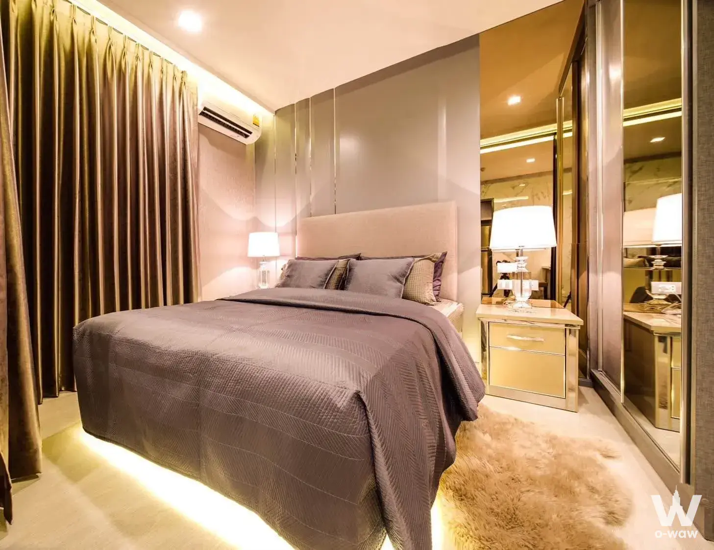 Master bedroom with king bed, LED underglow, and mirrored wardrobe in a Rhythm Sukhumvit 36-38 condo for rent