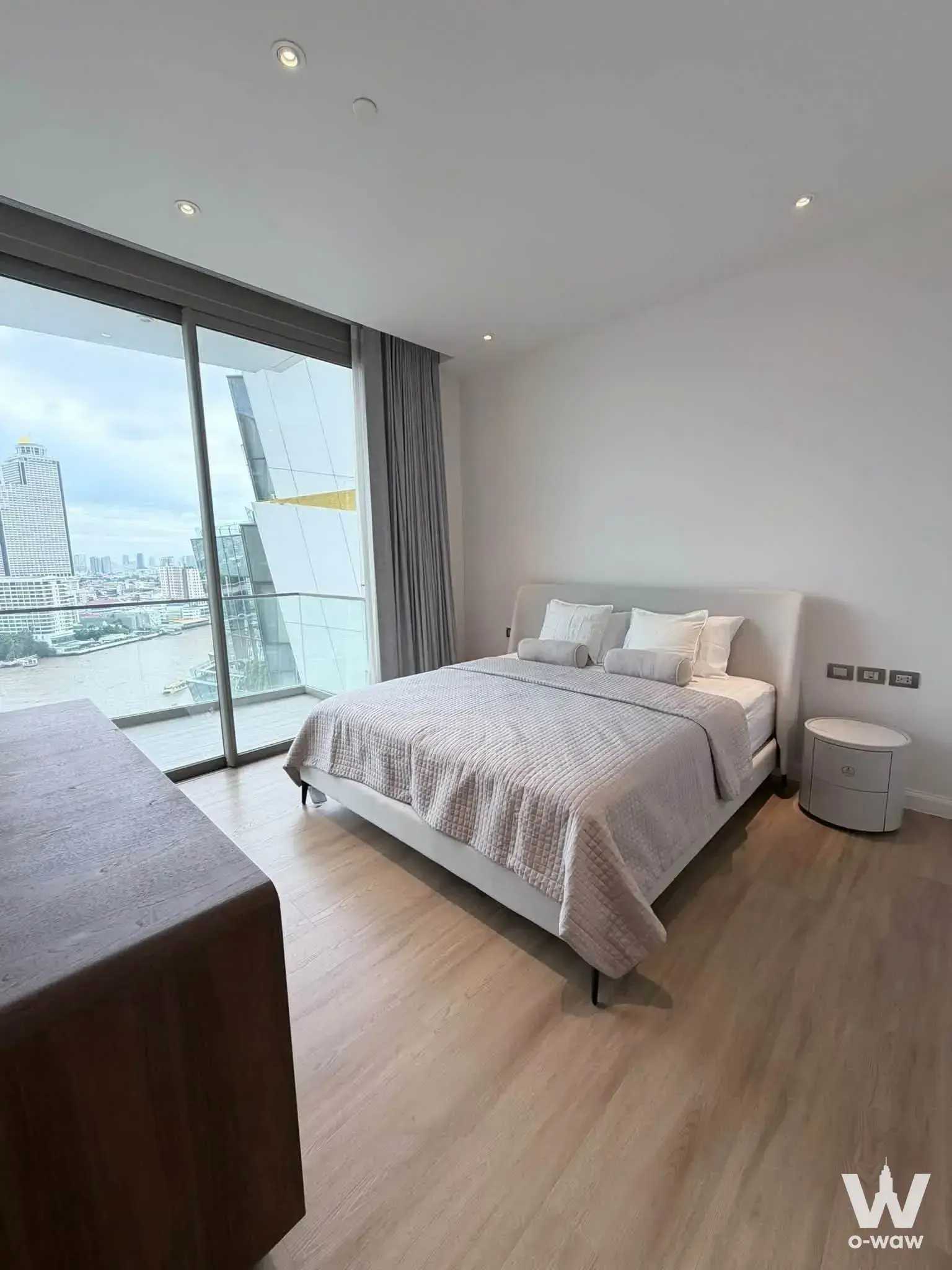 This master bedroom in a 1-bed condo for rent at Magnolias Waterfront Residences has a queen bed and river-view balcony