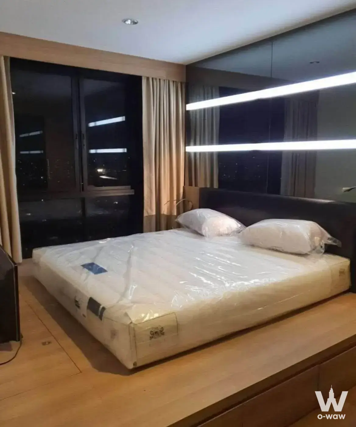 Master bedroom in a 2-bed rental at The Tree Interchange featuring a wood platform bed and city view