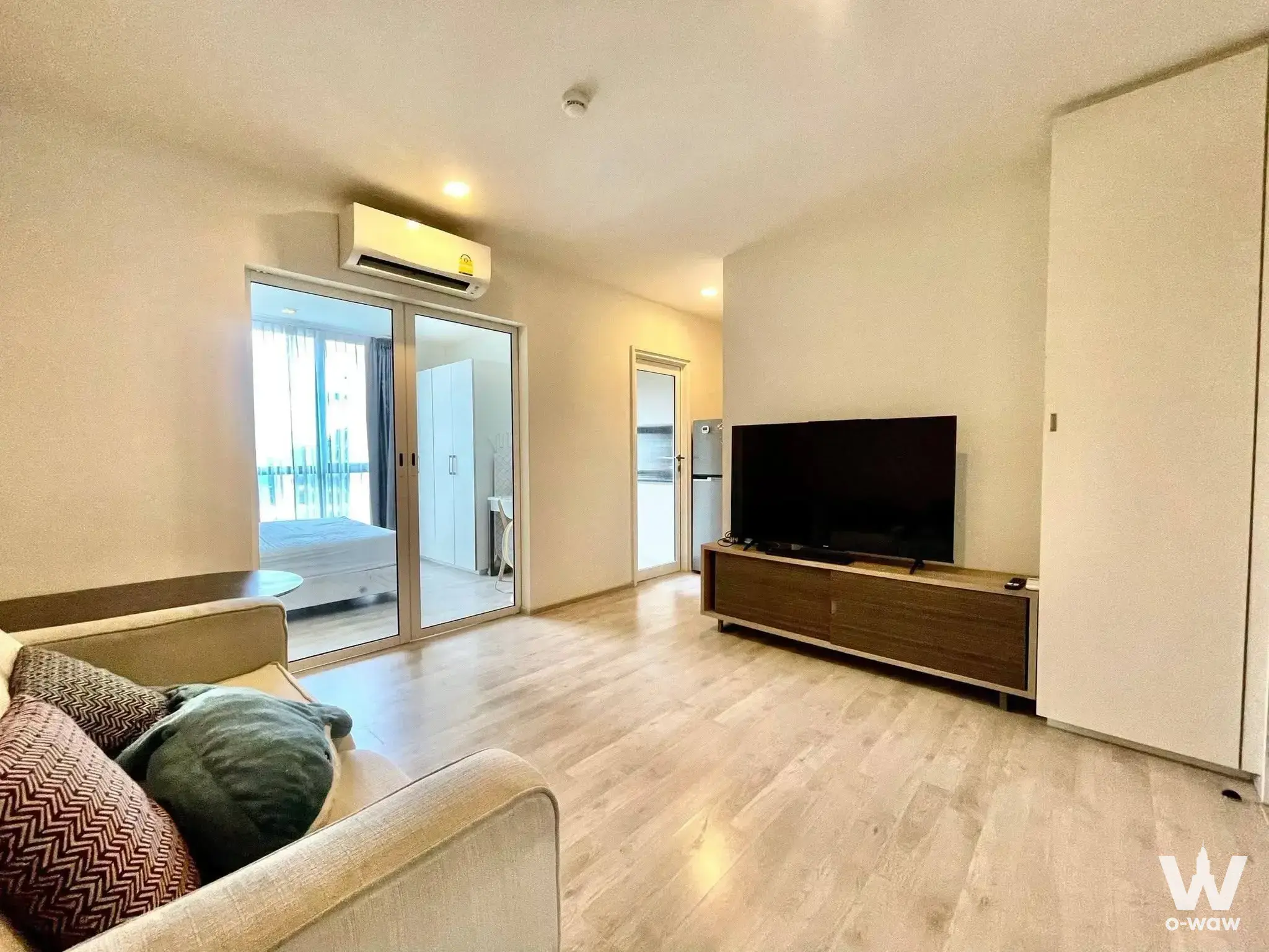 Living room for sale in Chambers Cher with walnut media console and balcony access