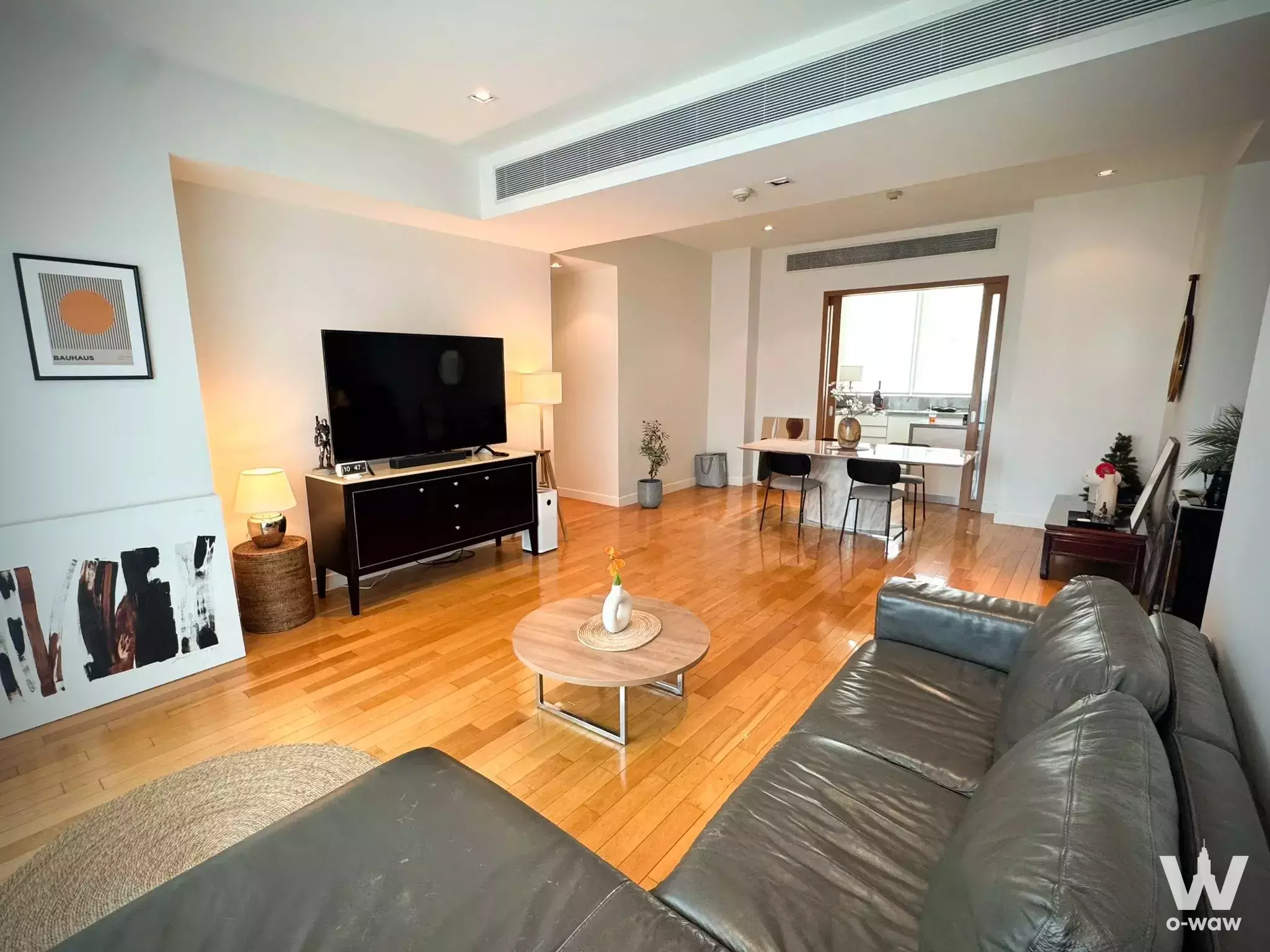 Leather sectional and dining area in this 3-bed condo for sale at Millennium Residence