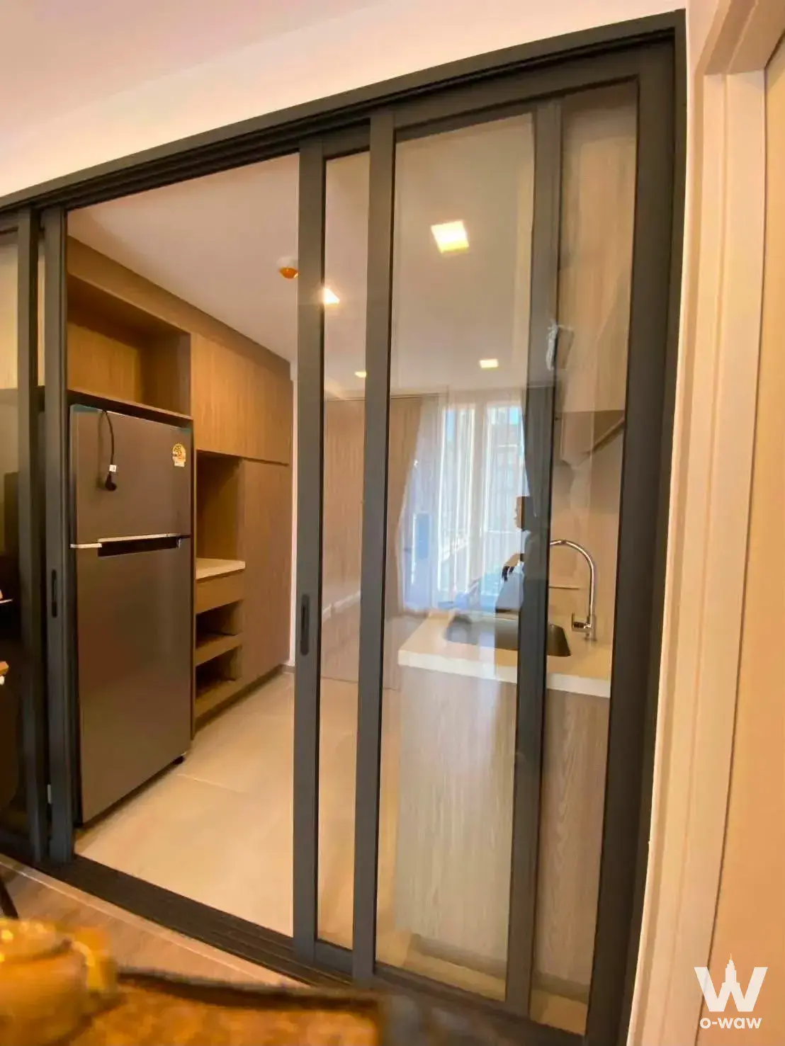 Modern The Nest Chula-Samyan kitchenette with black metal glass partition and light oak cabinets
