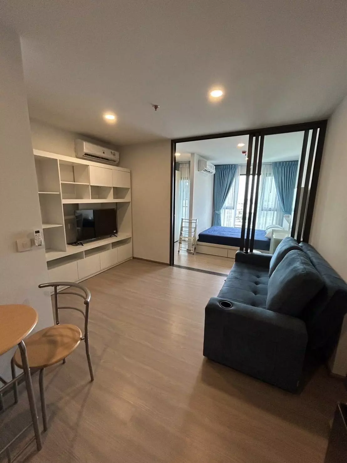 Living room in Aspire Sukhumvit-Rama 4 featuring a grey sofa and sliding glass bedroom divider