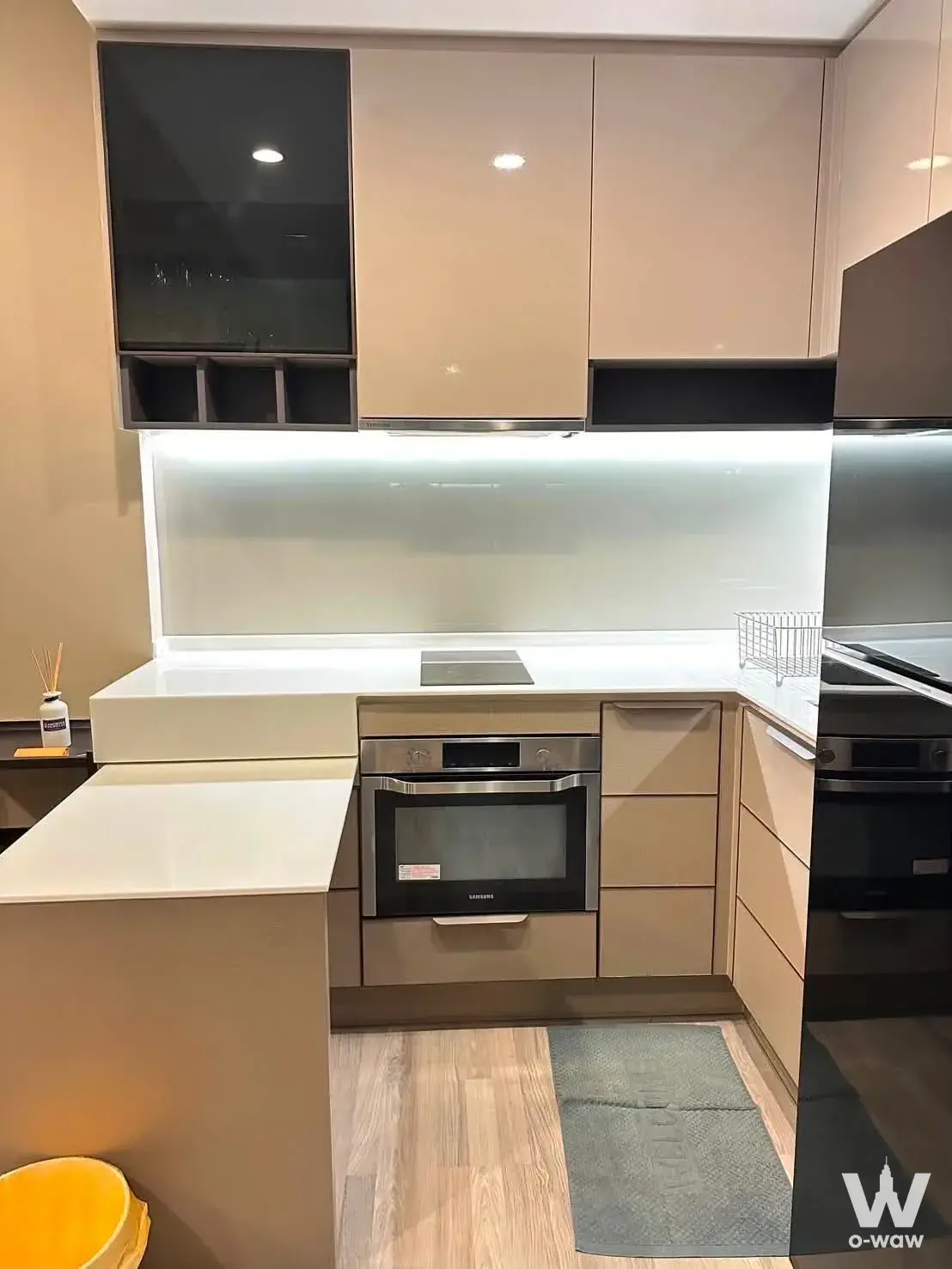 Modern 1-bed condo kitchen for rent in 333 Riverside featuring beige high-gloss cabinets and under-cabinet LED lighting