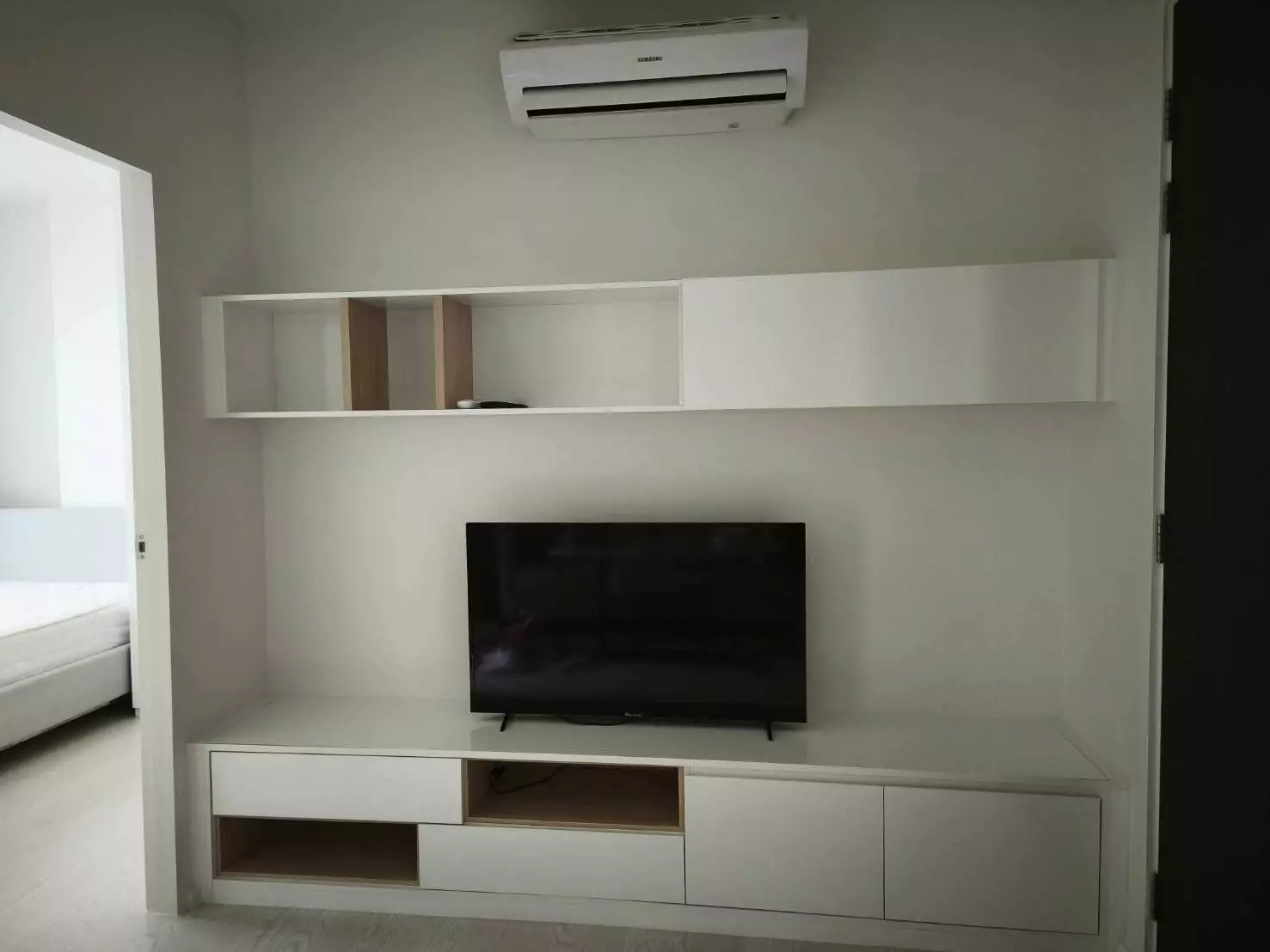 Minimalist living room with built-in entertainment center in The Prodigy Condo MRT Bangkhae