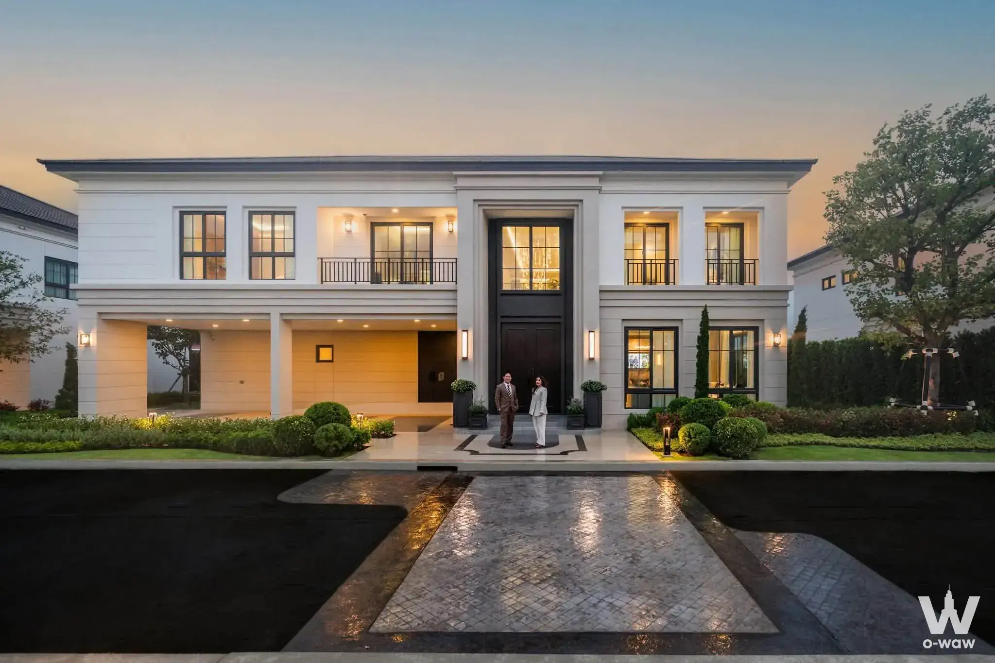 5-bed villa exterior for sale in The City Ramintra-Wongwaen 2 showing symmetrical facade, black glass doors, and dusk
