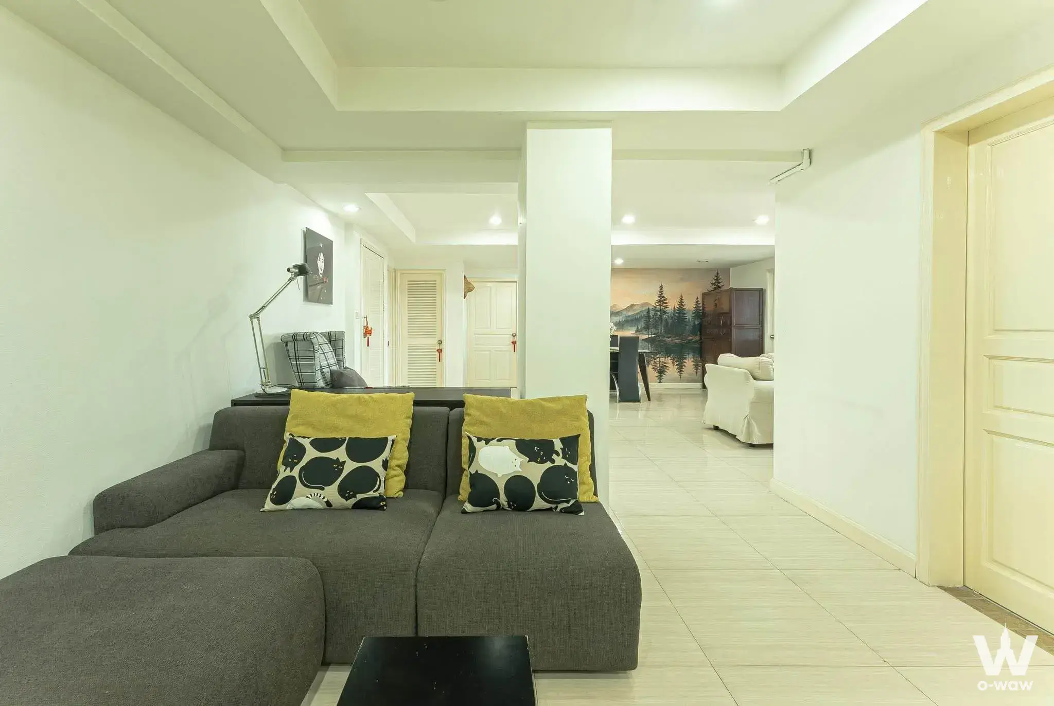 Living room with mustard pillows and landscape mural in Sribumpen Condo Home
