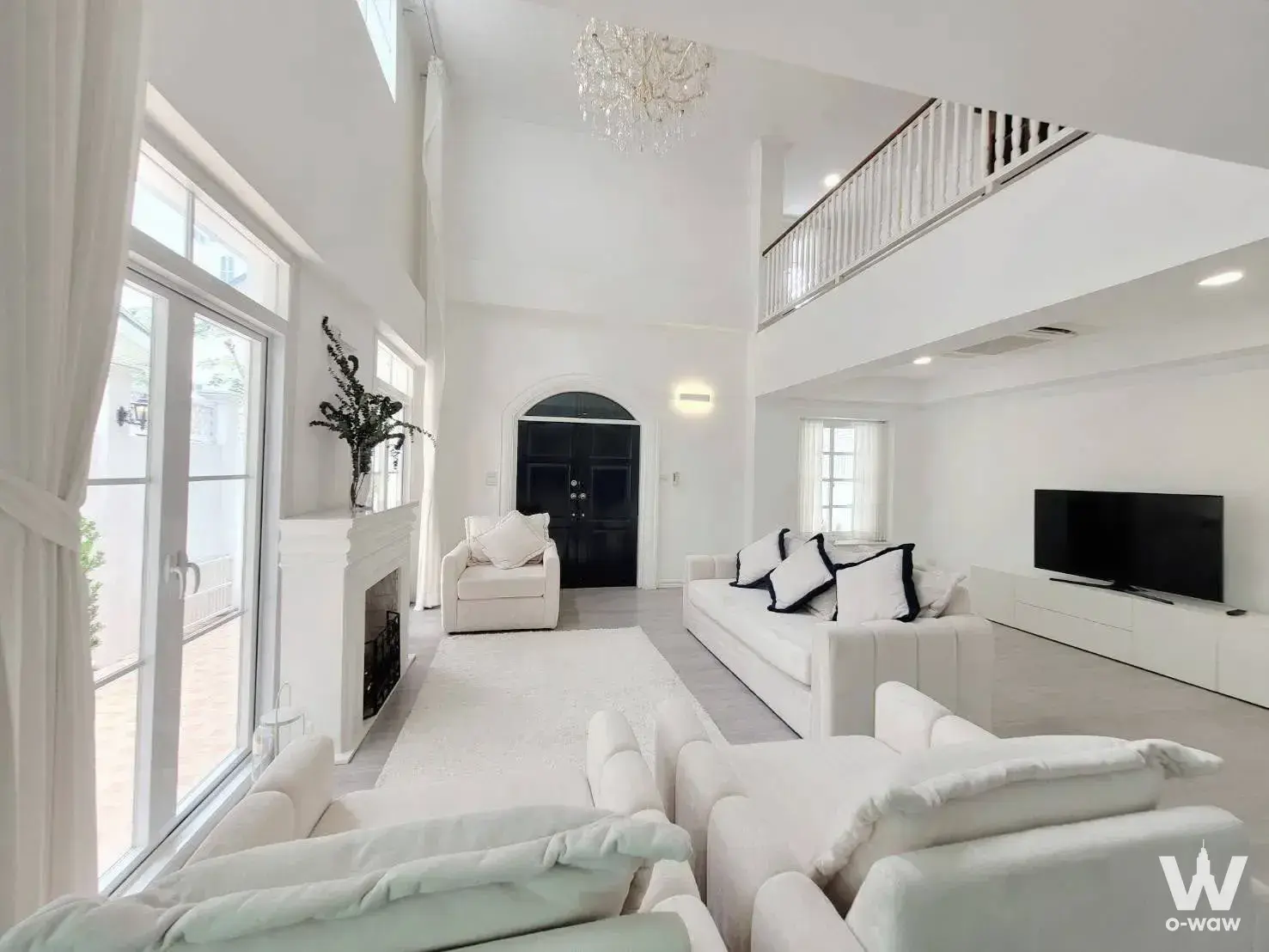 Double-height living room in Fantasia Villa2 4-bed house featuring cream sofas and crystal chandelier