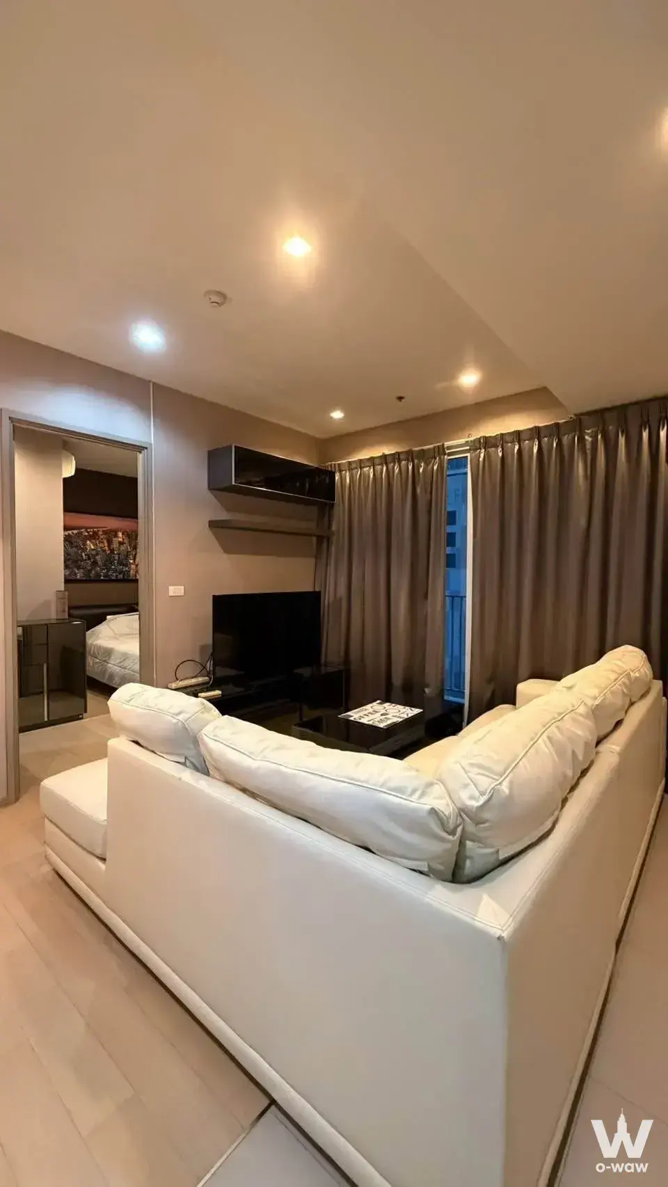 Modern 1-bed HQ by Sansiri condo living room with white sectional and TV
