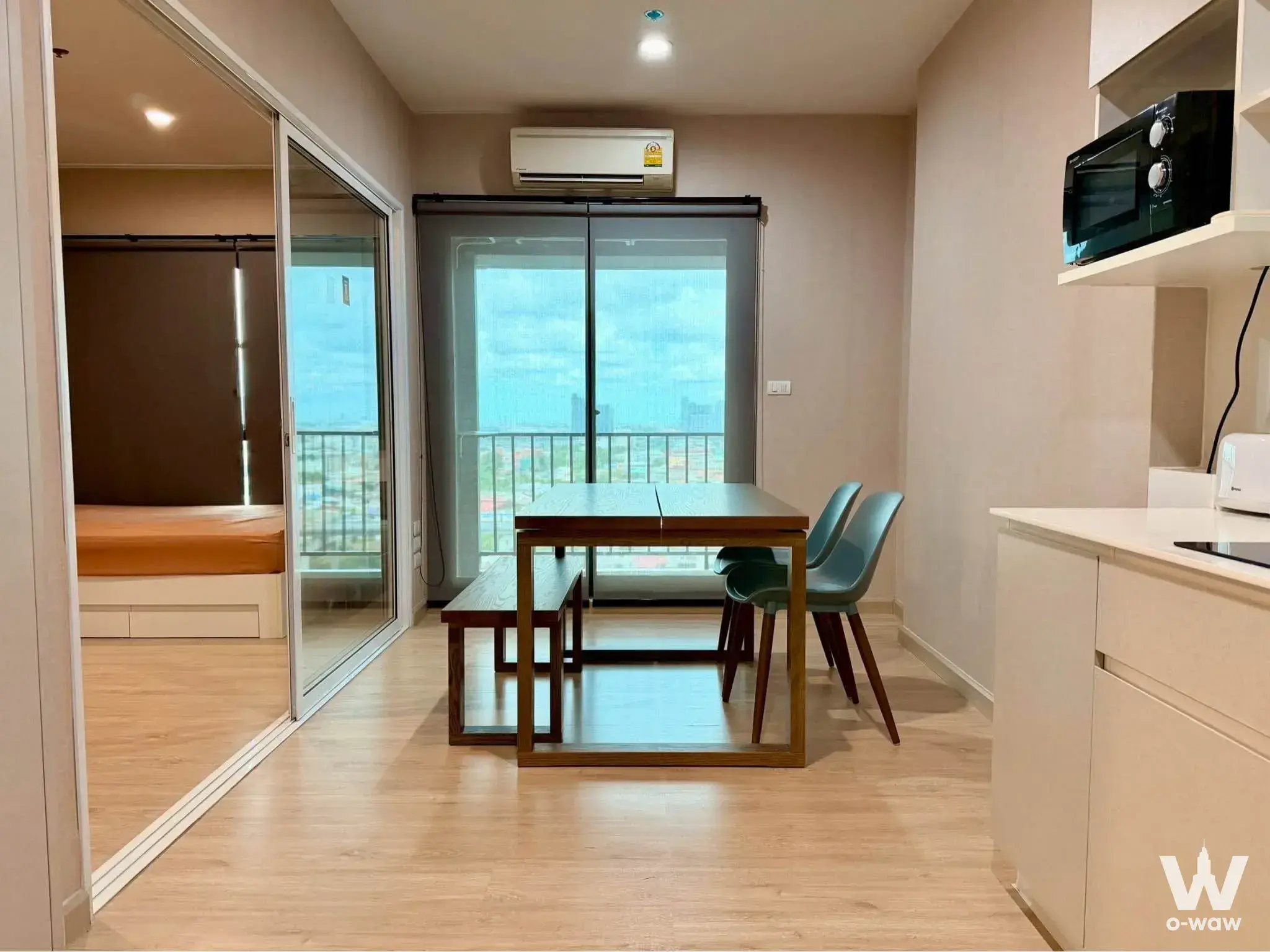Dining area in The Parkland Phet Kasem-Tha Phra condo featuring teal chairs and city view