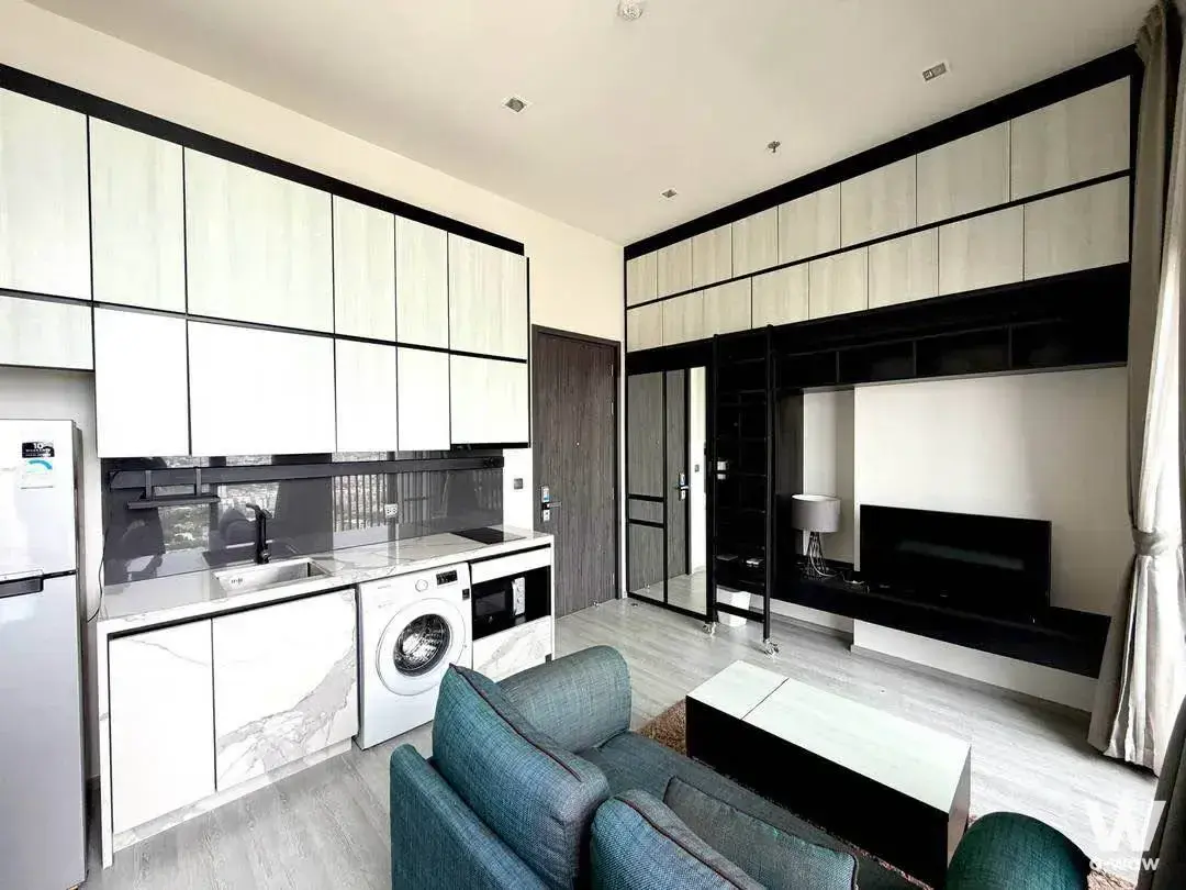 Teal accent sofa and marble-look kitchenette in THE LINE Sukhumvit 71 modern studio apartment