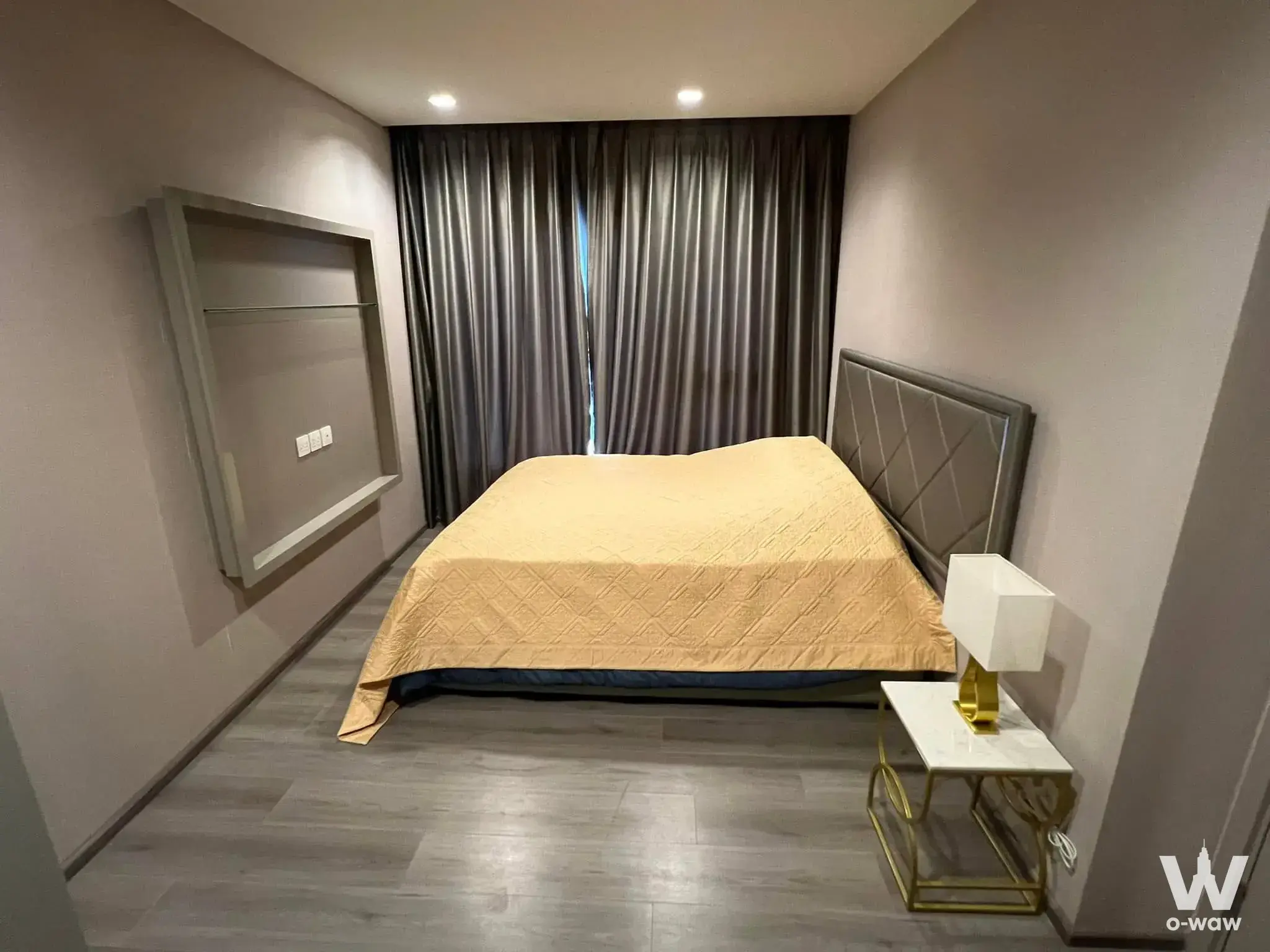 Queen bed with yellow duvet and grey headboard in a 2-bed condo for rent at The Politan Rive