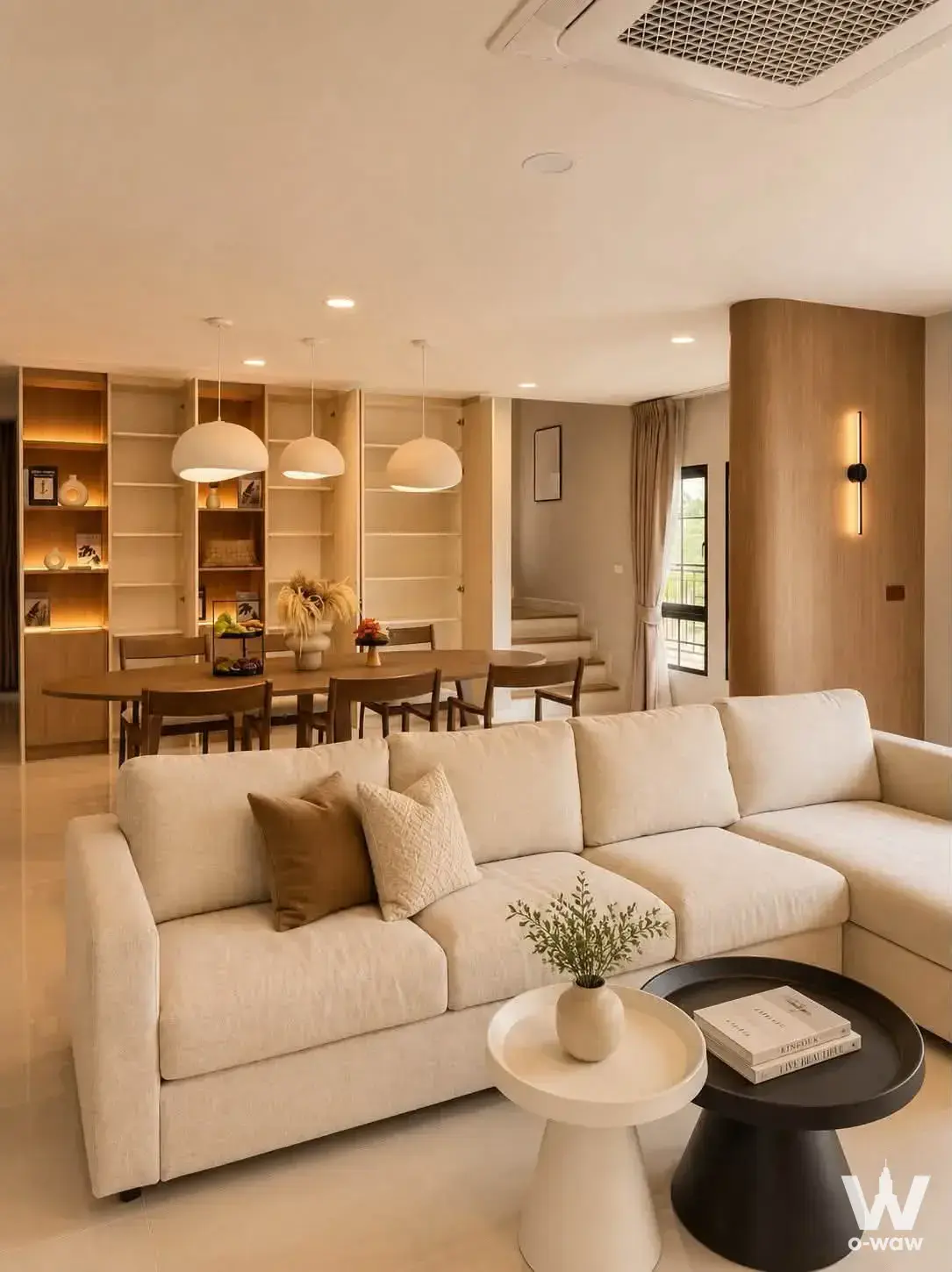 Spacious living area in Centro Bangna house with cream sectional sofa and built-in wood shelving