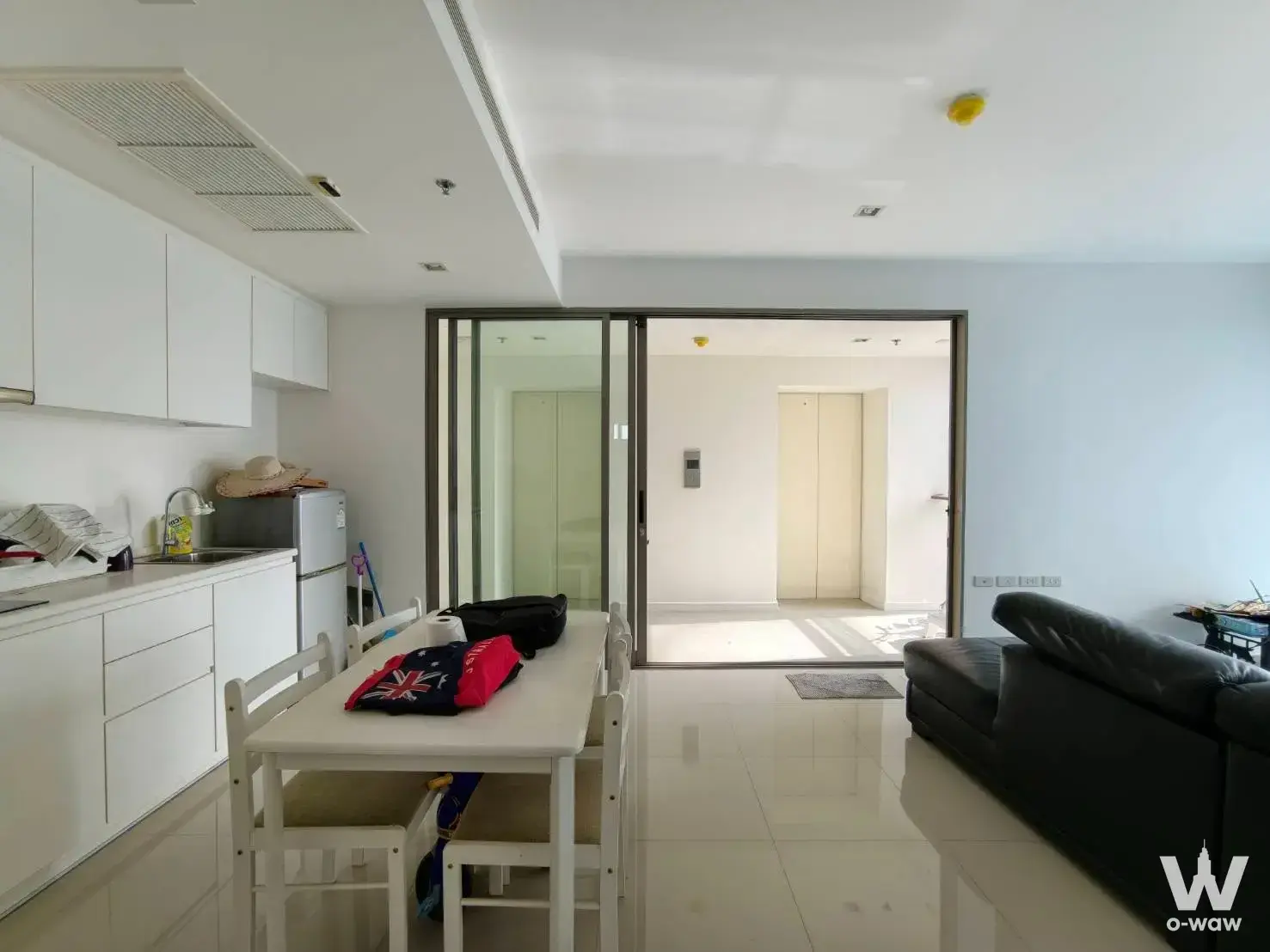 Open-plan living and kitchen area in a 2-bed condo for sale at StarView Rama 3 featuring white cabinets and glossy cream