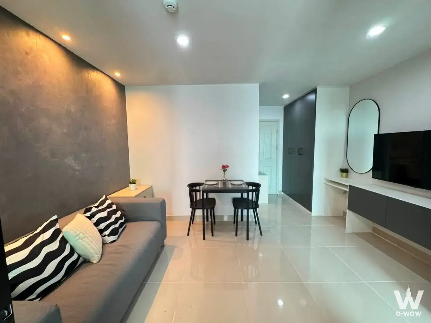 Living area in Regent Home 18 featuring a grey sofa and dark accent wall