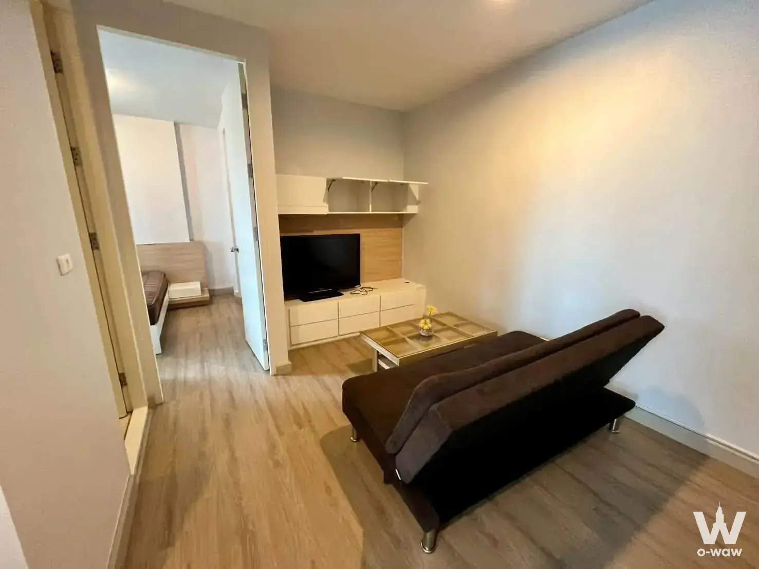 Studio living area with glass coffee table and white media console in The Parkland Srinakarin Lakeside