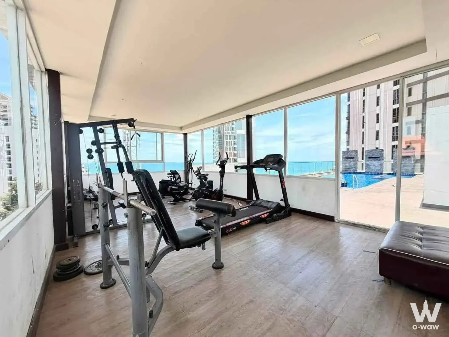 Bright gym with ocean views and modern cardio equipment at Serenity Wongamat condo