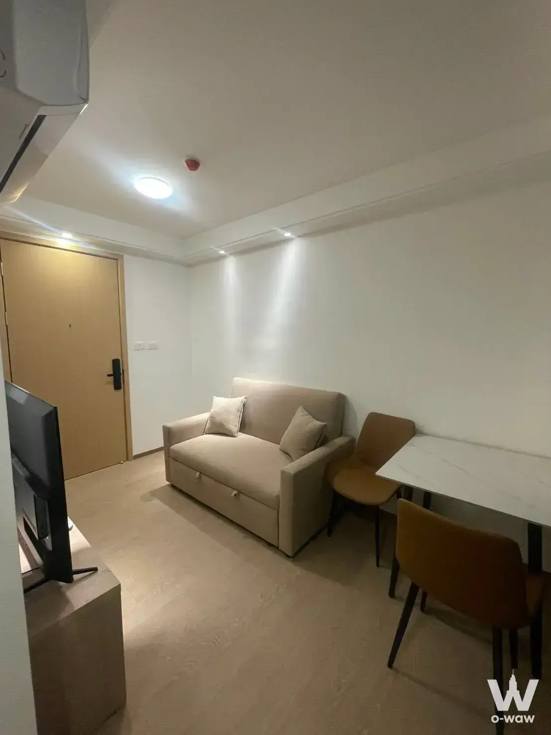 1-bed condo for rent in Regal Srinakarin 40 with beige sofa bed and minimalist living area