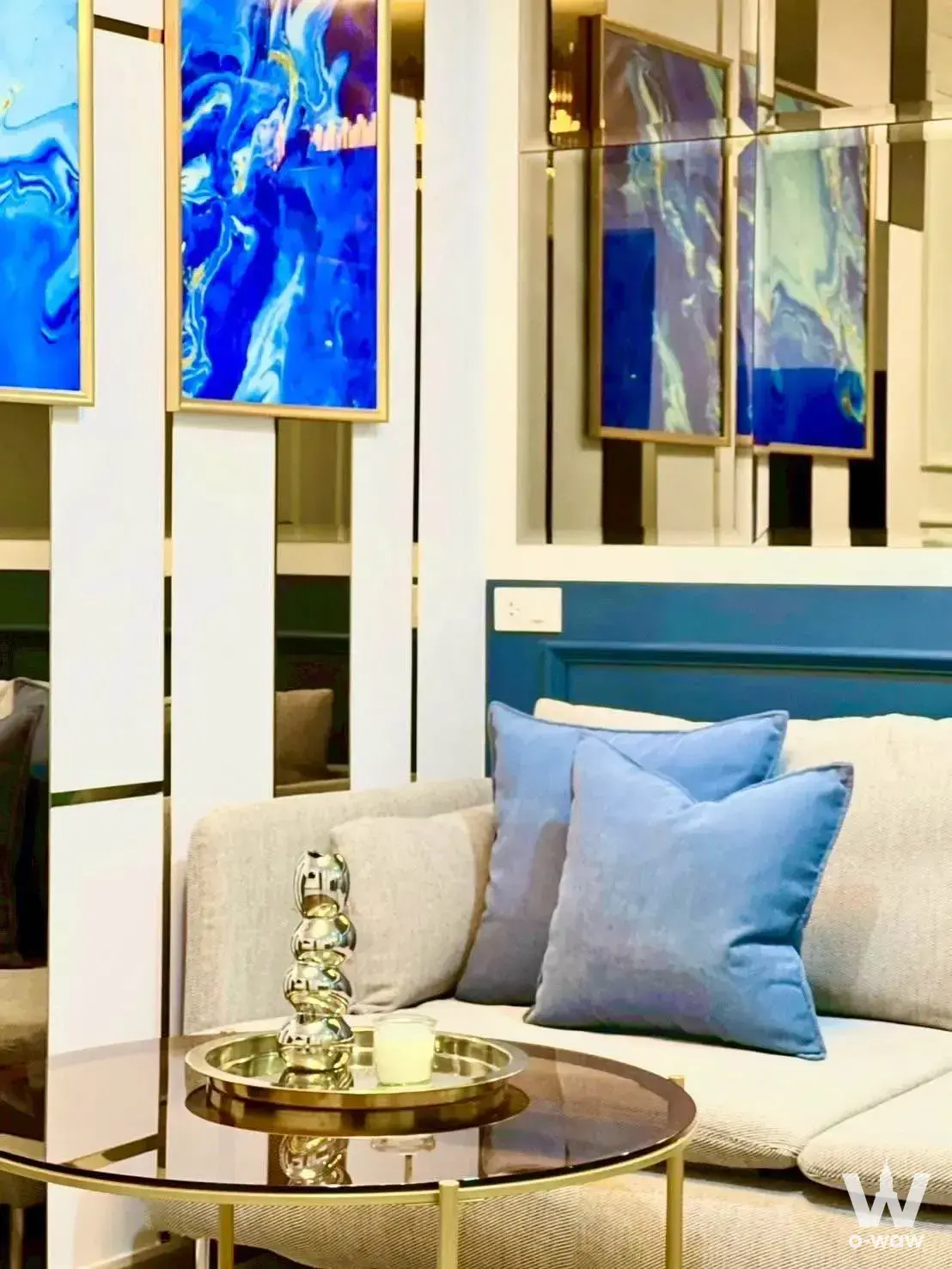 Lumpini Condo Town living room showcasing beige sectional, royal blue accents, and gold trim details