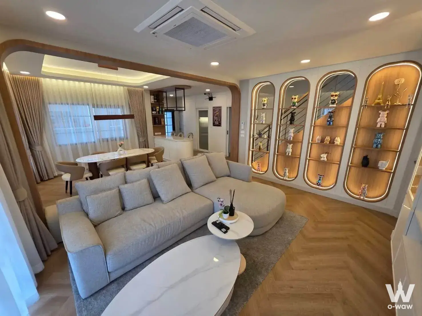 Centro Bangna living area with curved sofa, marble table, and arched display niches
