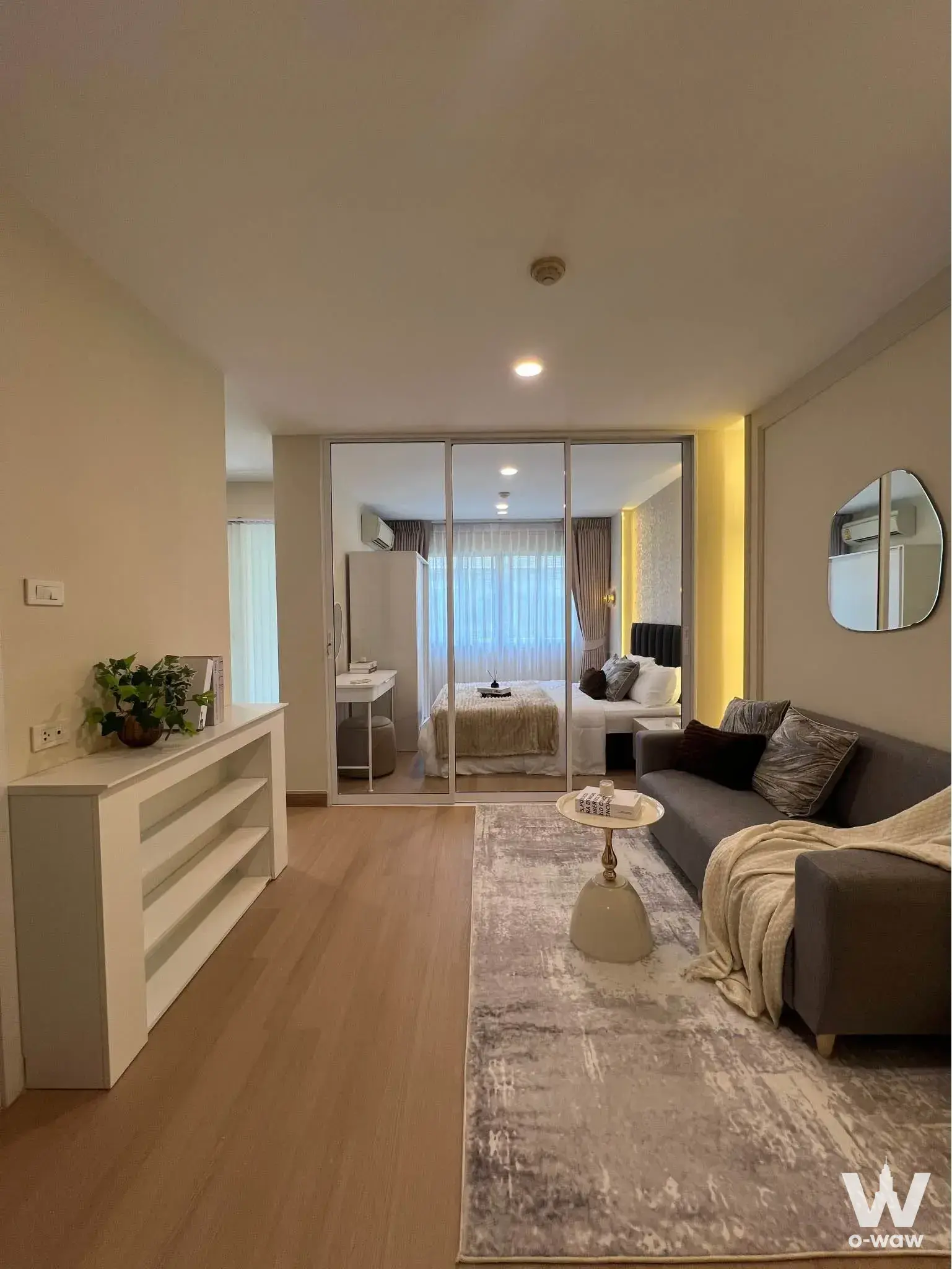 Furnished studio in Lumpini Condo Town Bodindecha-Ramkhamhaeng with open plan living area and glass partition to sleeping