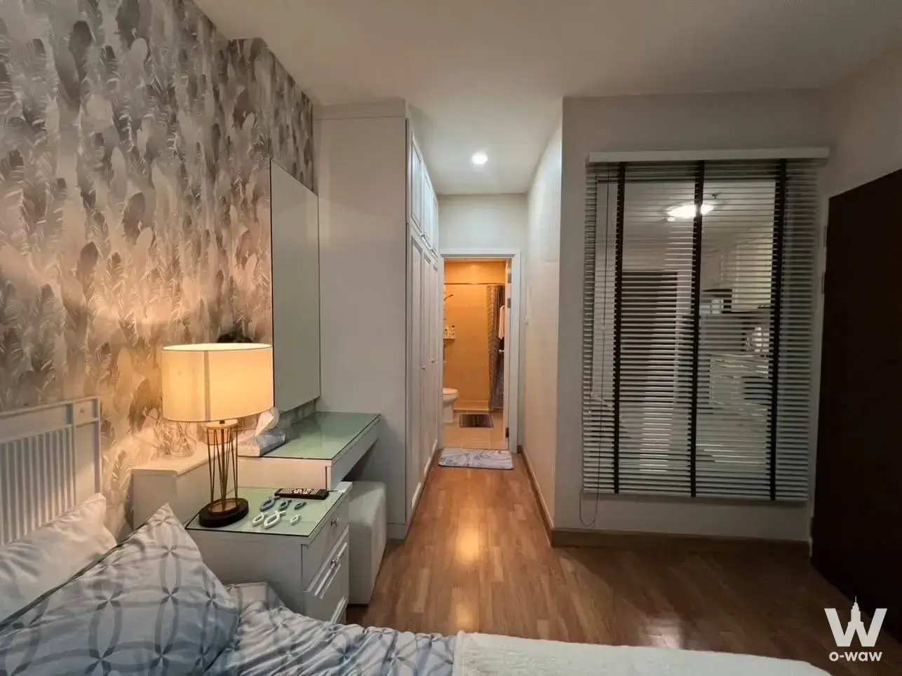 Bedroom with green vanity desk and feather wallpaper for sale in Ivy River condo