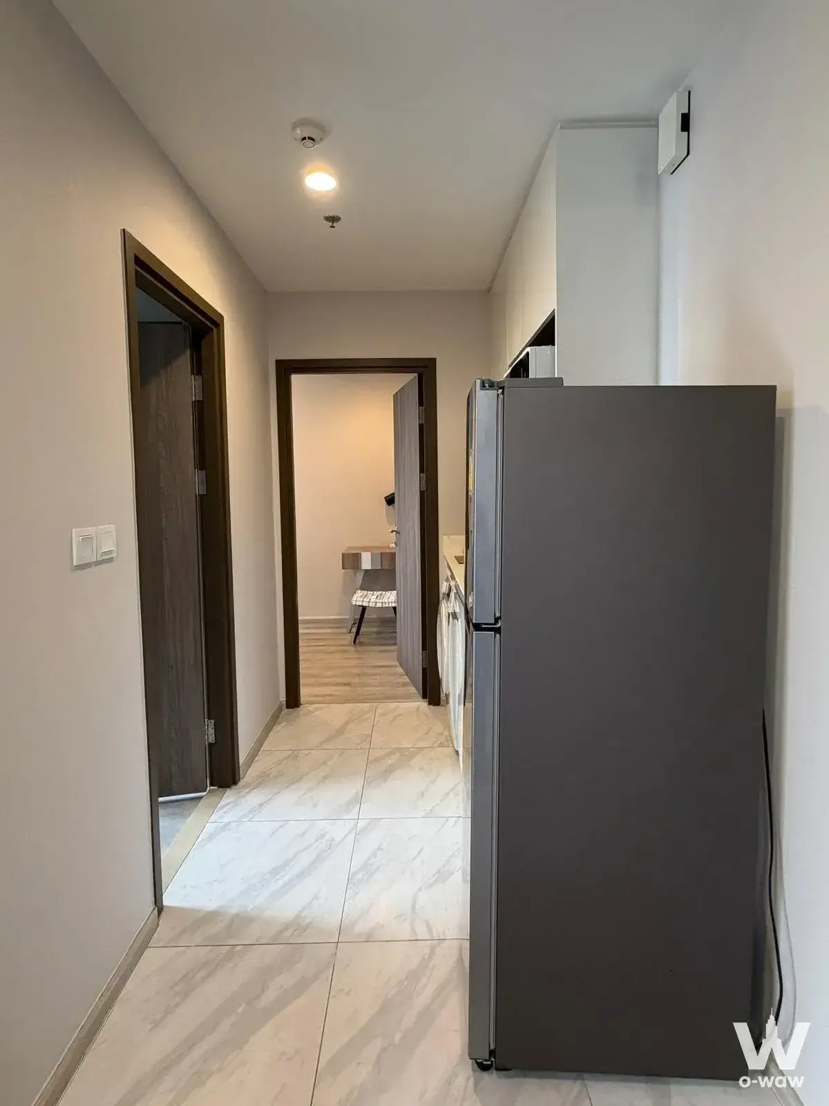 Ideo Mobi Asoke 1-bed condo corridor with fridge, marble floor, and bedroom access