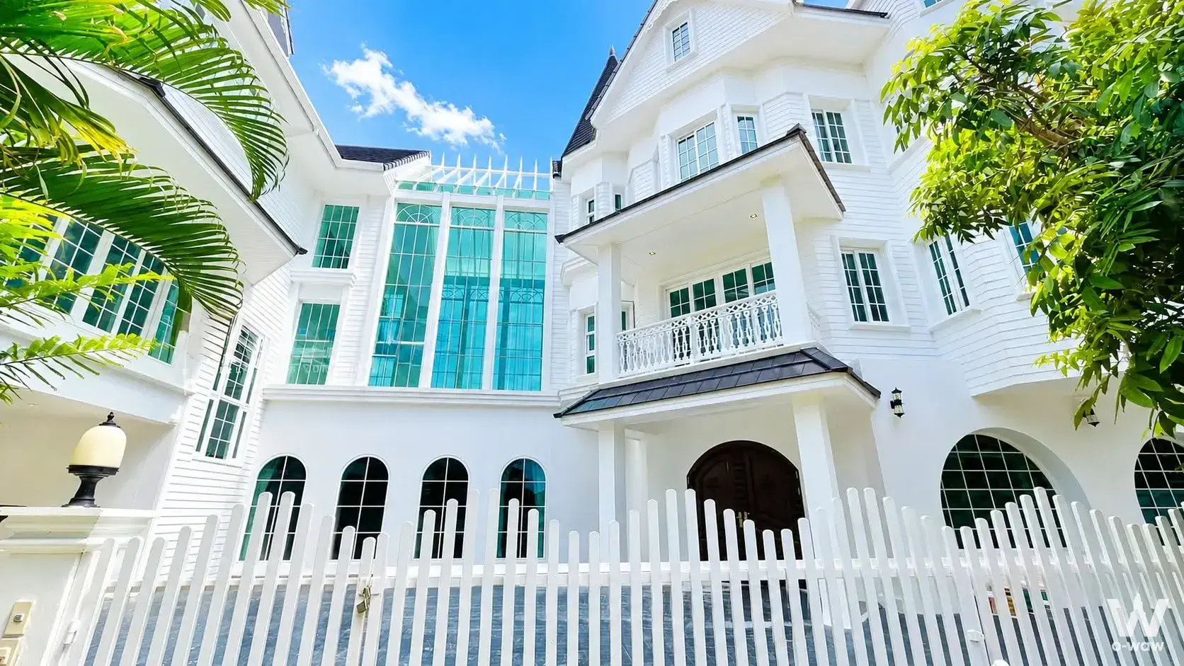White colonial mansion exterior in Fantasia Villa2 with teal glass facade and arched entrance