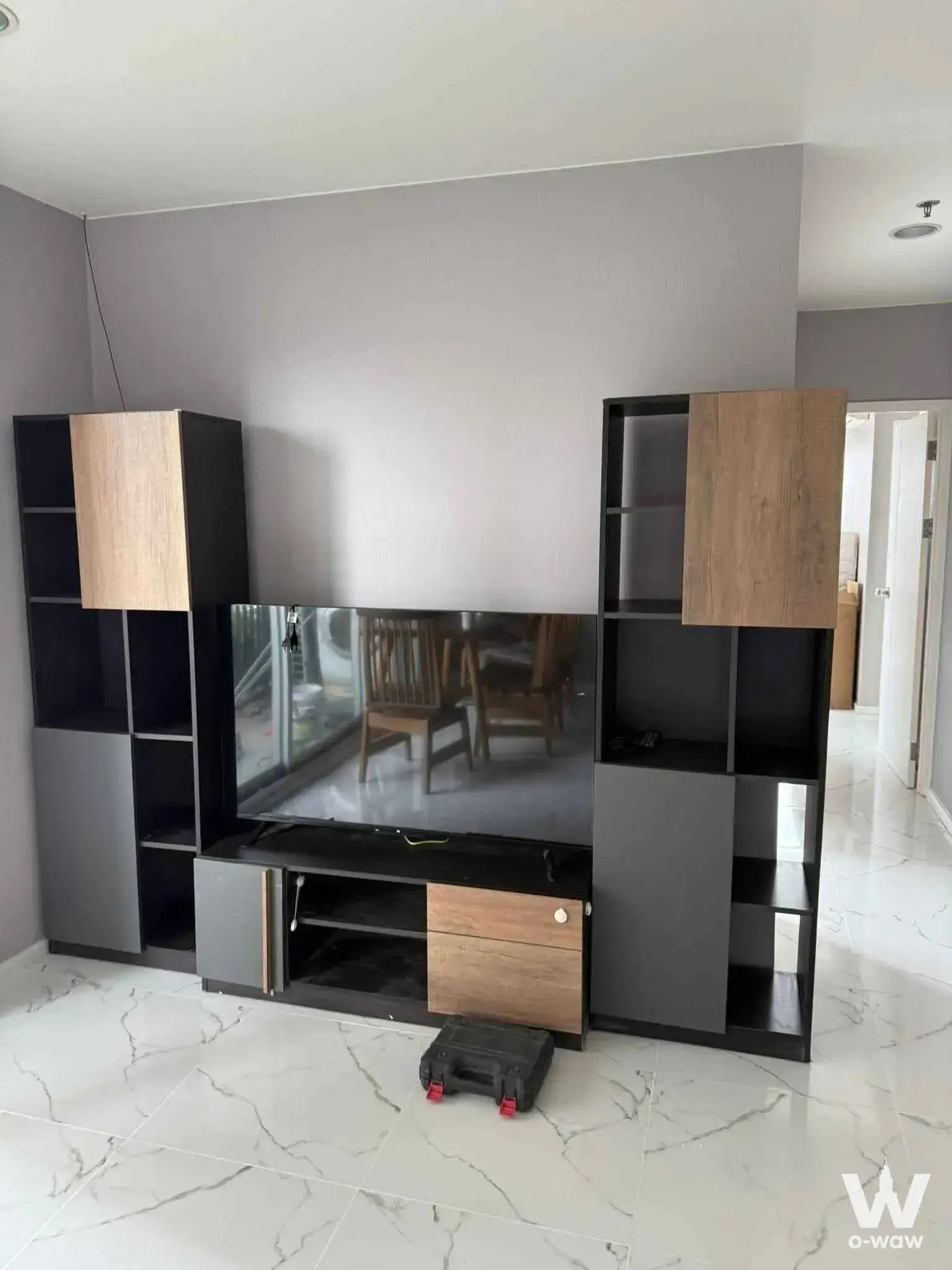 Living room with a modular entertainment center and marble-look floor in this 2-bed rental at Fuse Chan Sathorn