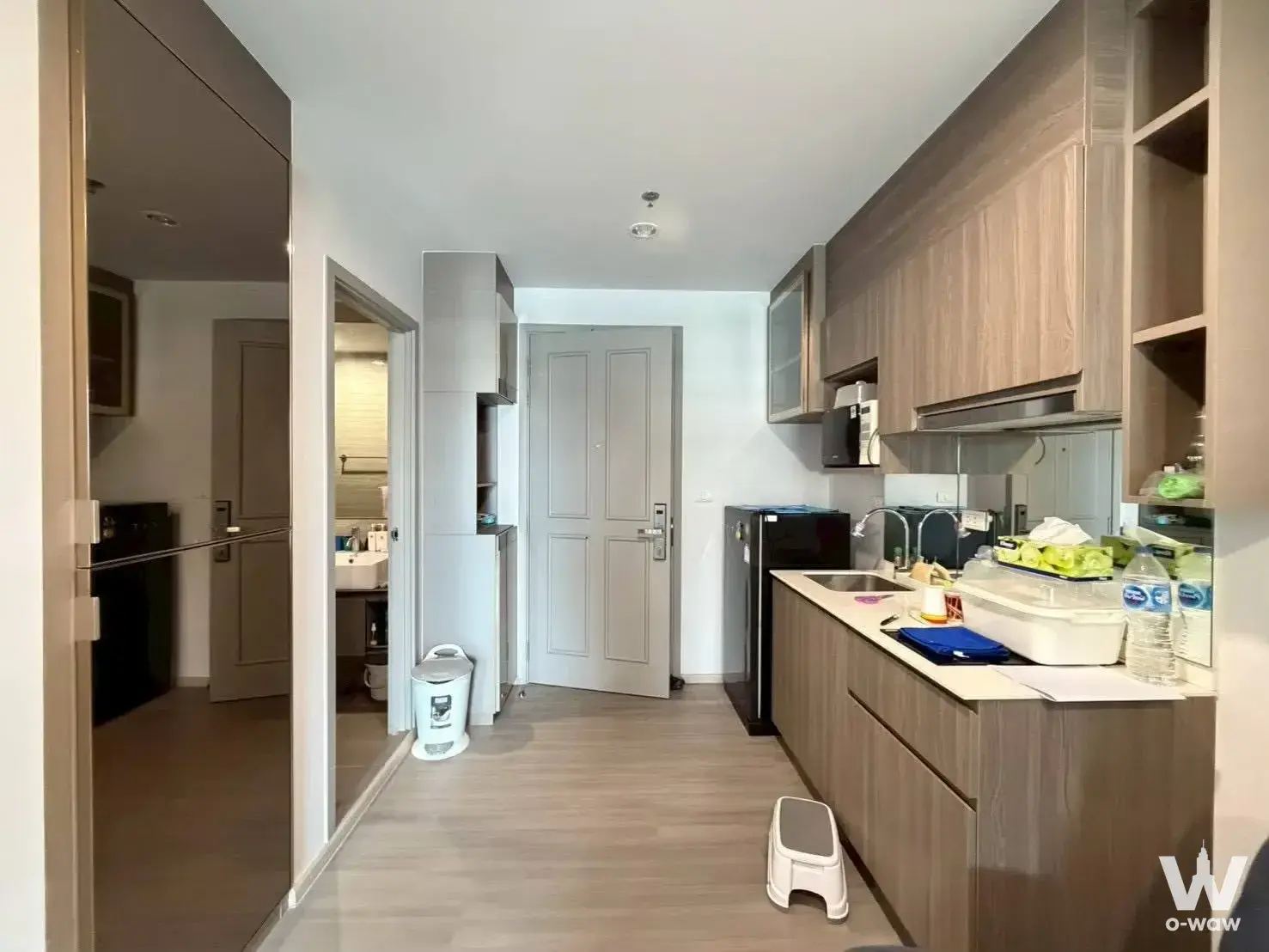 Entry hallway and galley kitchen of a 1-bed condo for rent in The Parkland Charan-Pinklao with full-length mirror and