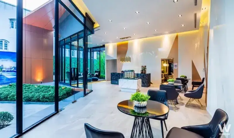 Lobby of The Collect Ratchada 32 featuring black leather chairs and gold accents