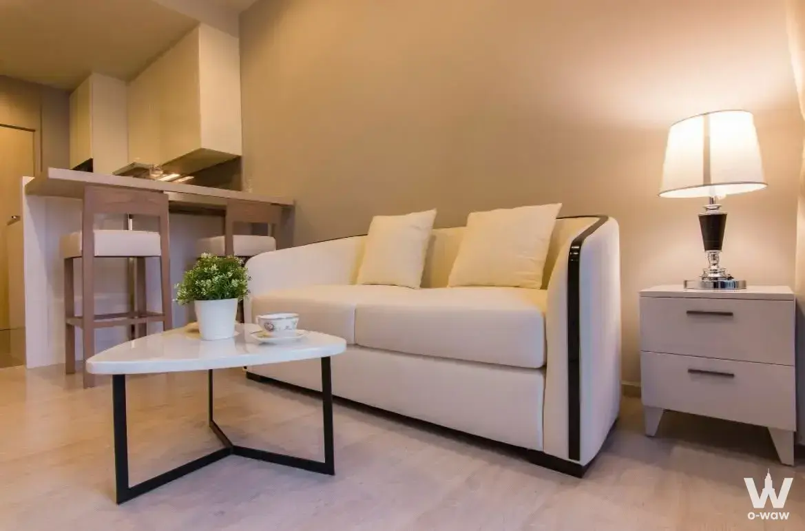 Compact living area in a Thonglor condo with a cream sofa and marble coffee table