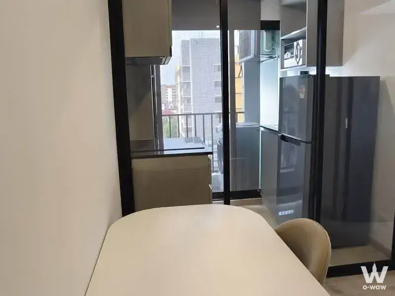 Compact dining area in a 1-bed condo at Galileo Ratchada 32 with white table and glass partition