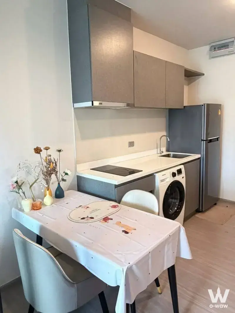 Kitchen and dining area in a 1-bed Life Asoke Hype condo with an induction cooktop and dining table