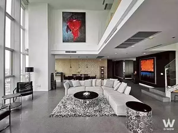 Luxury living room in The River Condominium with double-height ceilings and grey sectional