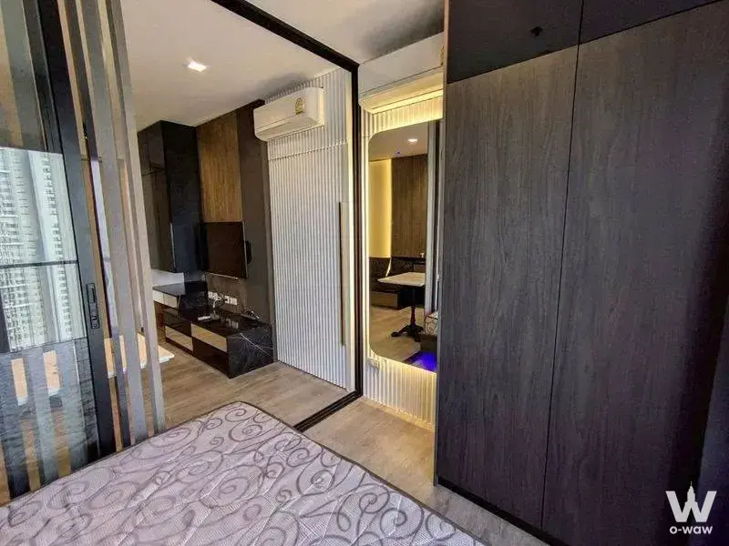 1-bed condo bedroom in The Politan Rive with dark walnut wardrobe and city view