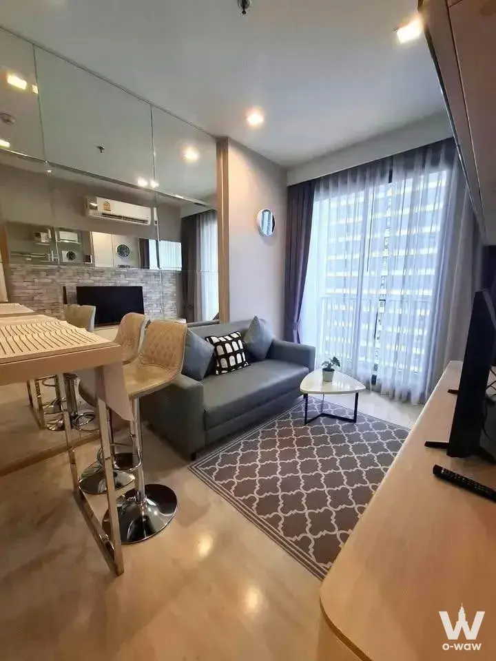 1-bed condo for rent in M Thonglor 10 with grey sofa, marble-look tile, and city view