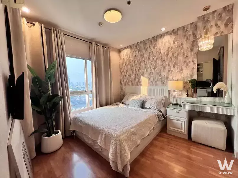Modern 1-bed condo bedroom in Ivy River with queen bed, oak floors, and a city skyline view