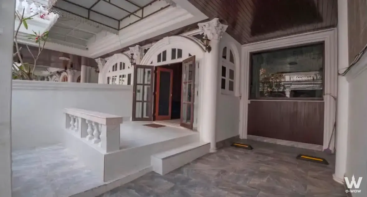 Classical colonial entrance porch at Ekkamai Villa with white columns and arched doors