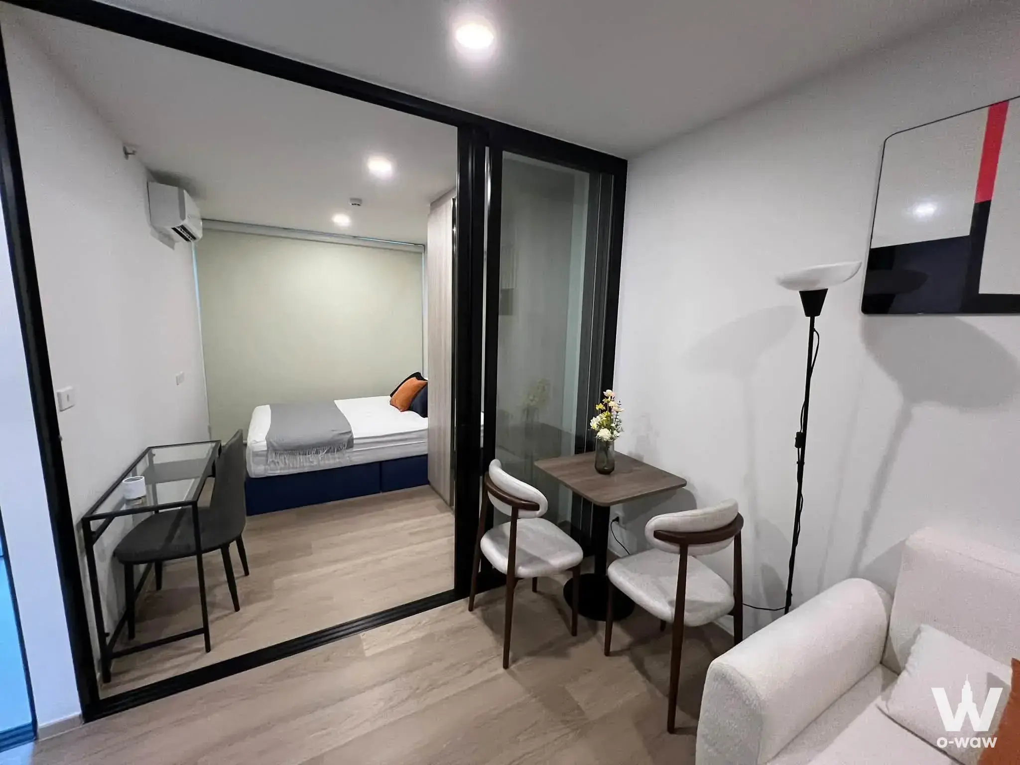 Studio condo living area with dining nook and glass bedroom partition at Origin Play