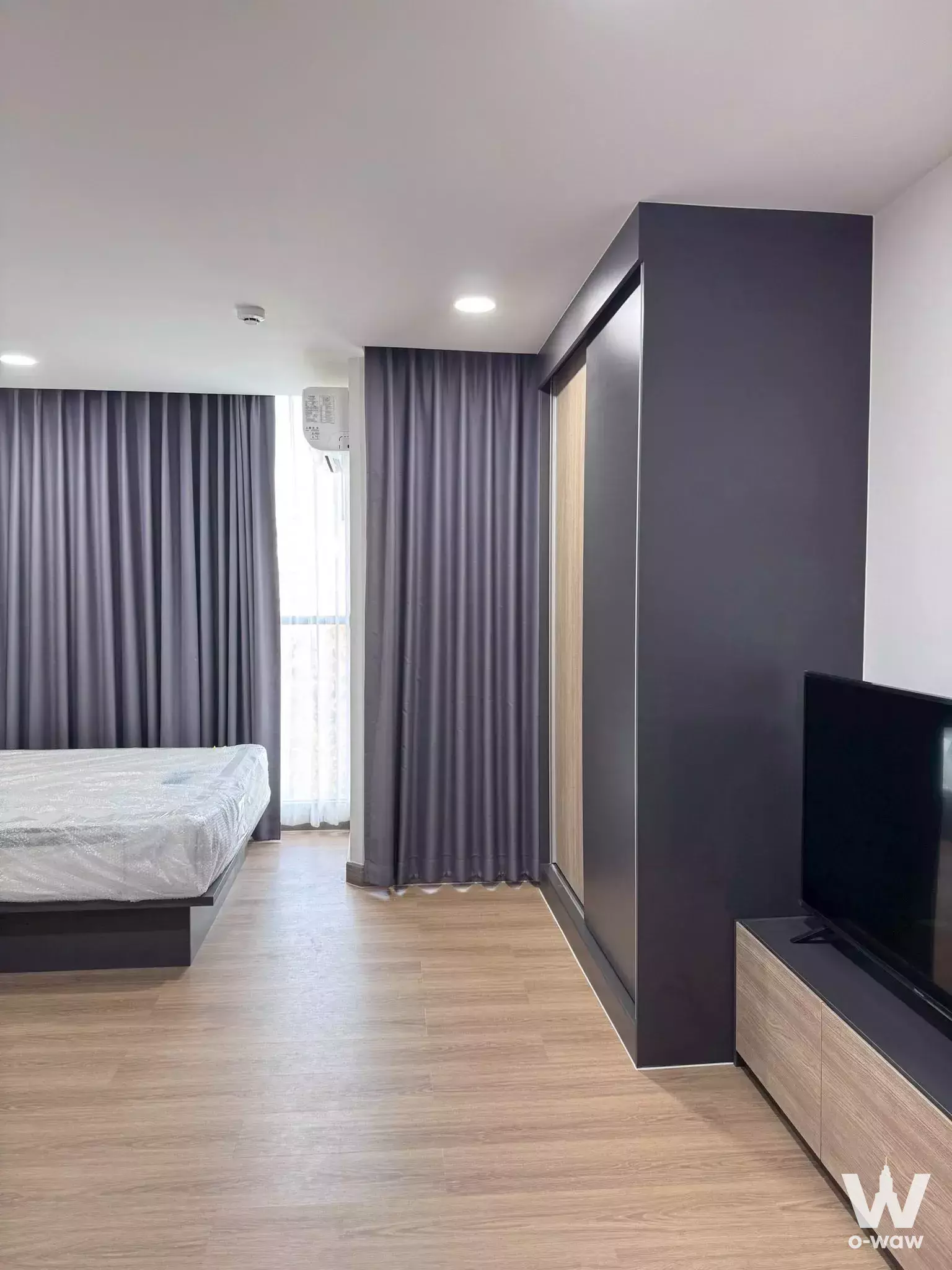 Unfurnished bedroom with dark wood wardrobe and balcony access in FLEXI Sathon-Charoen Nakhon rental
