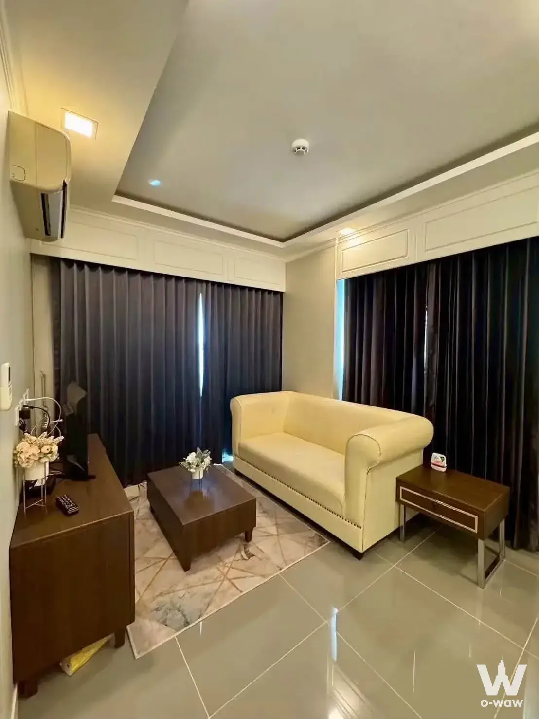 Cream leather sofa and dark wood furniture in a furnished 1-bed condo for rent at The Orient Resort & Spa