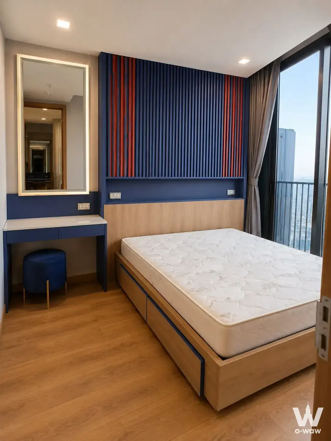 Bedroom in Noble BE33 with navy slat paneling and a high-floor balcony view of the city skyline