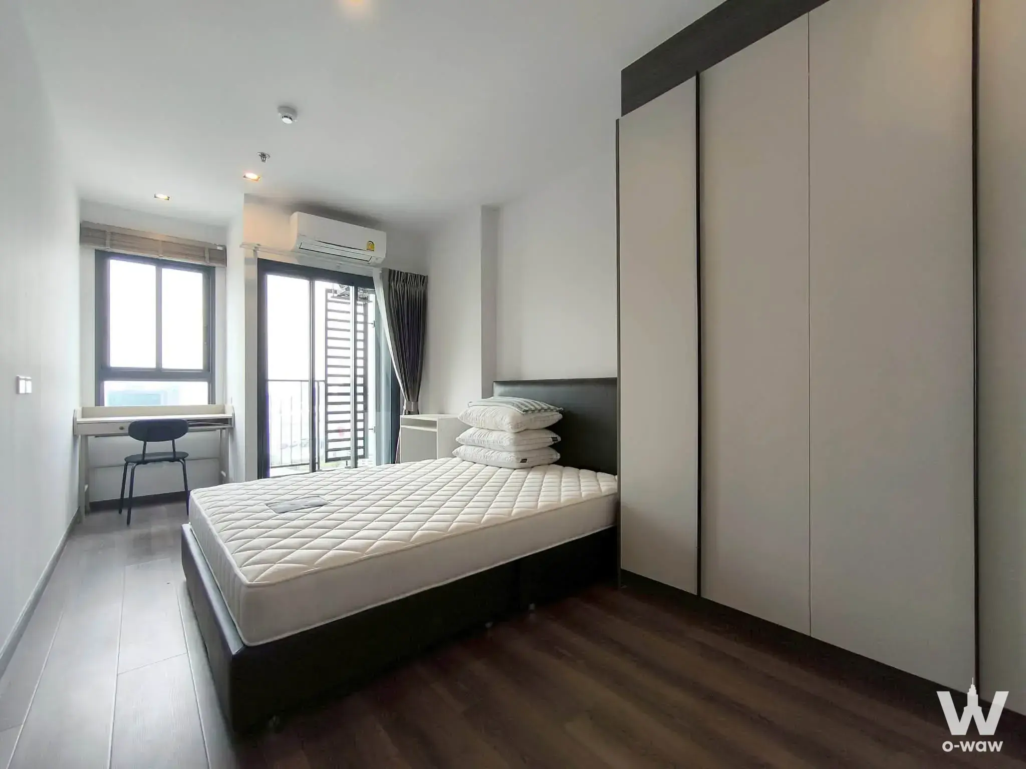 Bright IDEO Rama 9 bedroom with floor-to-ceiling wardrobes and balcony access