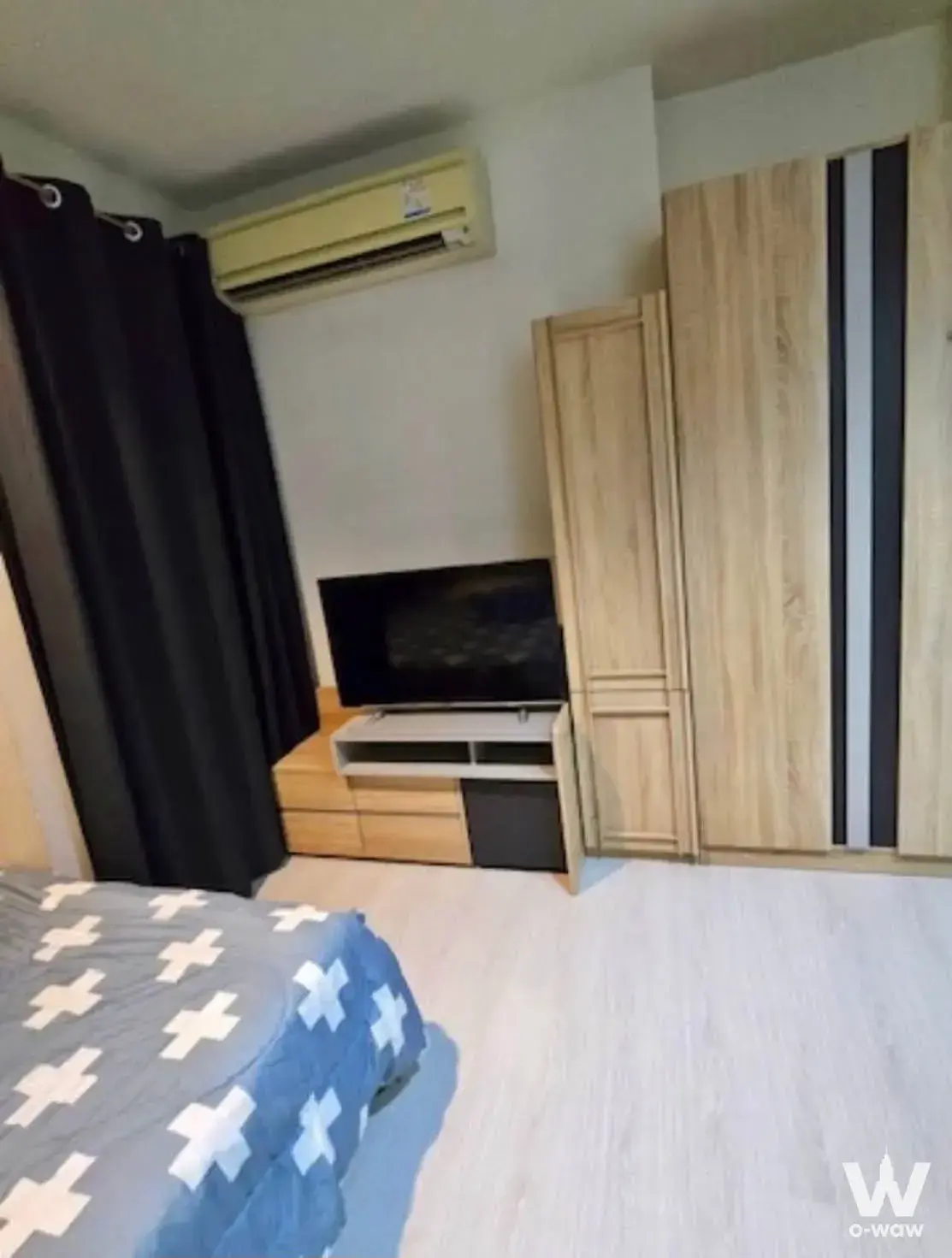 Bedroom featuring blue patterned bedding and a TV console in a 1-bed condo for rent at RHYTHM Asoke 2