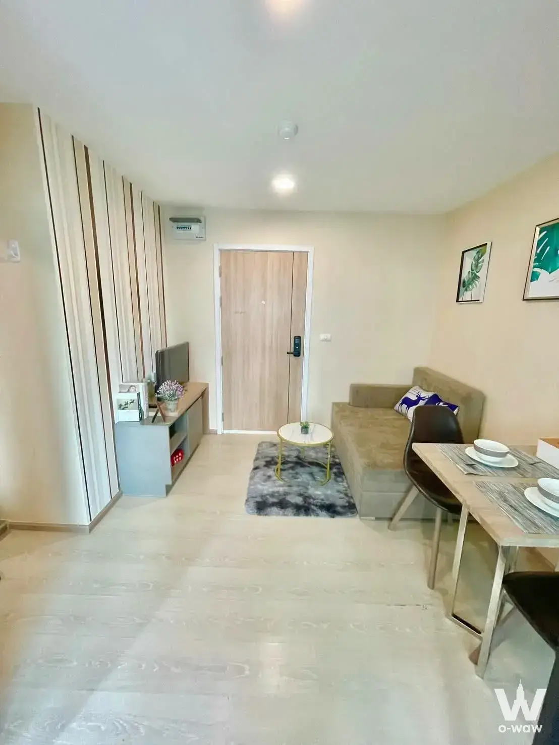 Open-plan 1-bed condo in The Excel Udomsuk with wood slat accent wall and marble coffee table