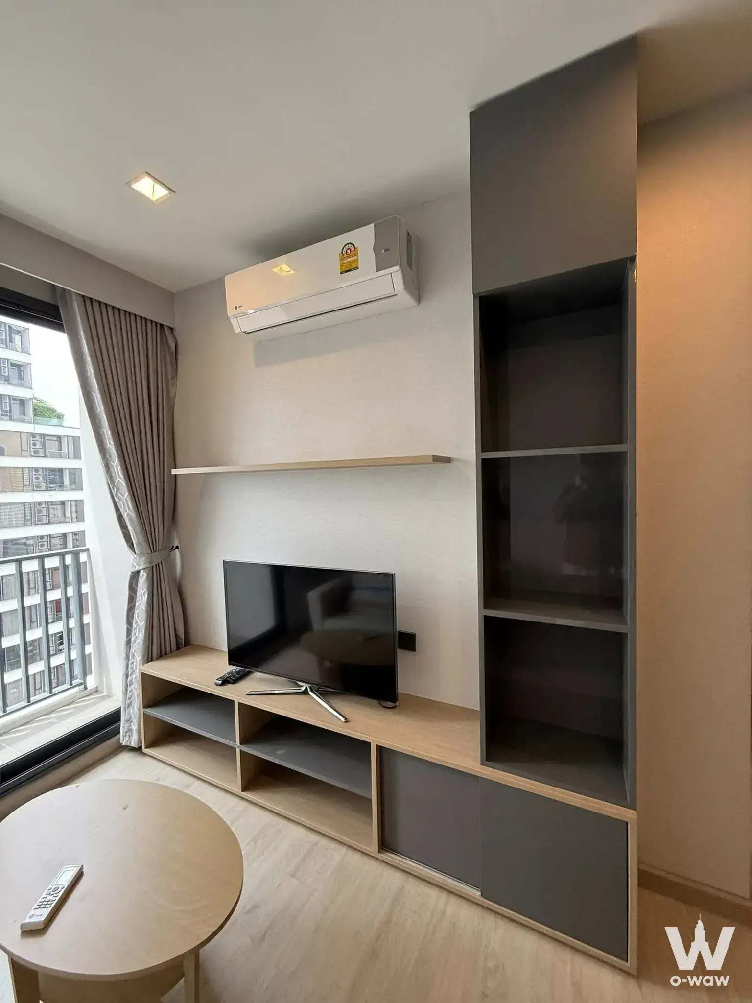 Living room featuring high-rise views and built-in media unit in a 2-bed condo for rent at M Thonglor 10