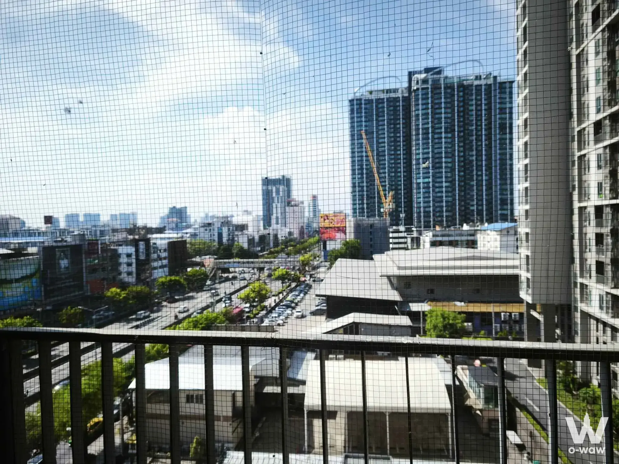 Balcony view from Noble BE33 2-bed condo overlooking a busy highway and dense urban skyline