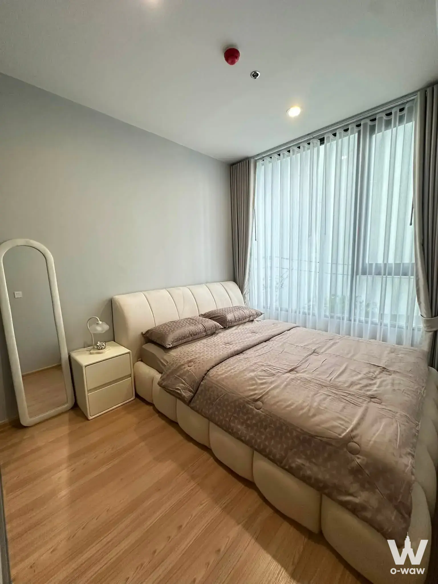 2-bed condo bedroom in Skyrise Avenue Sukhumvit 64 with cream tufted headboard